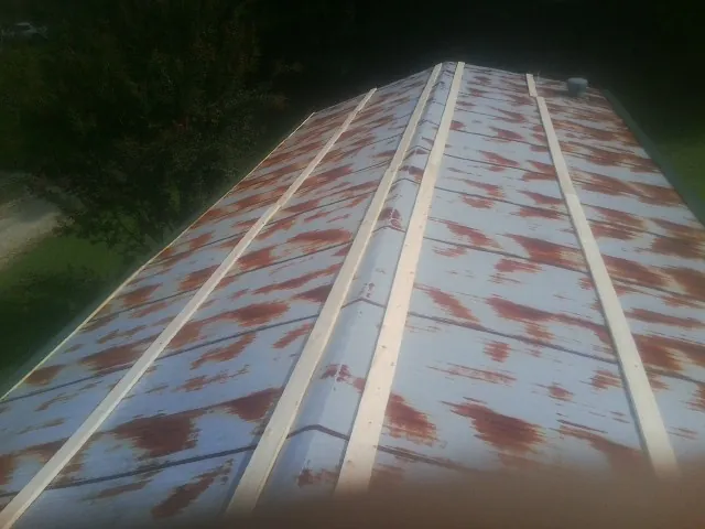 Rusted metal roof panels with new wood purlins before replacement — Storm Damage Roof Repair in Center City by Roofing Brothers