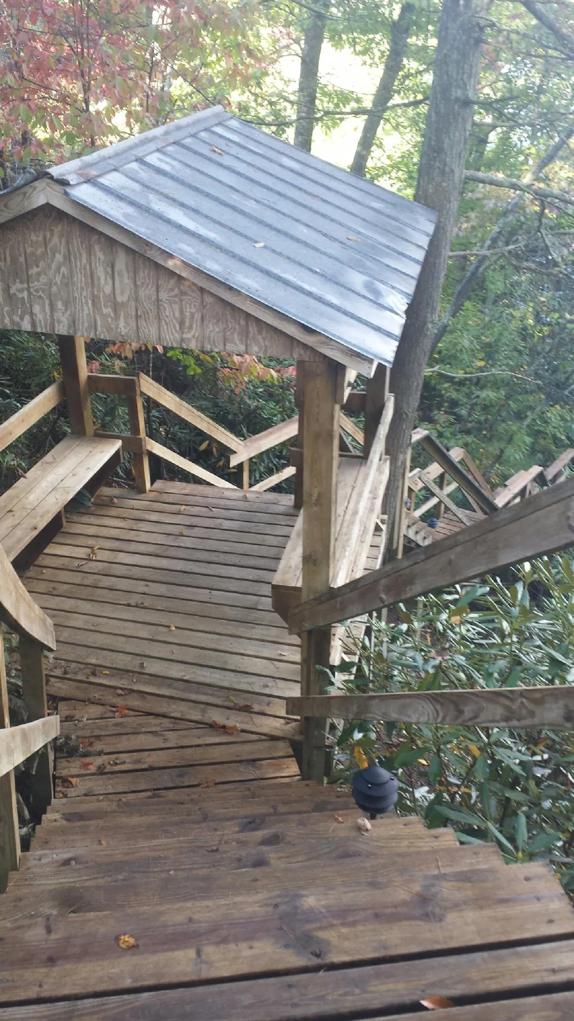 Metal roofed shelter over wooden steps on a wooded walkway — Skylight Repair & Installation work by our crew in Center City