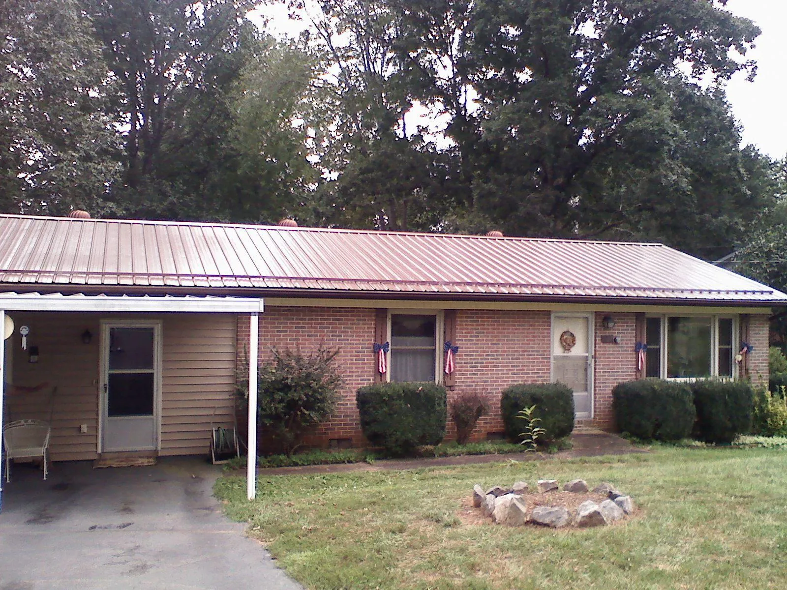 Bronze metal roof and carport on a brick ranch home — Roof Repair work by our crew in Center City