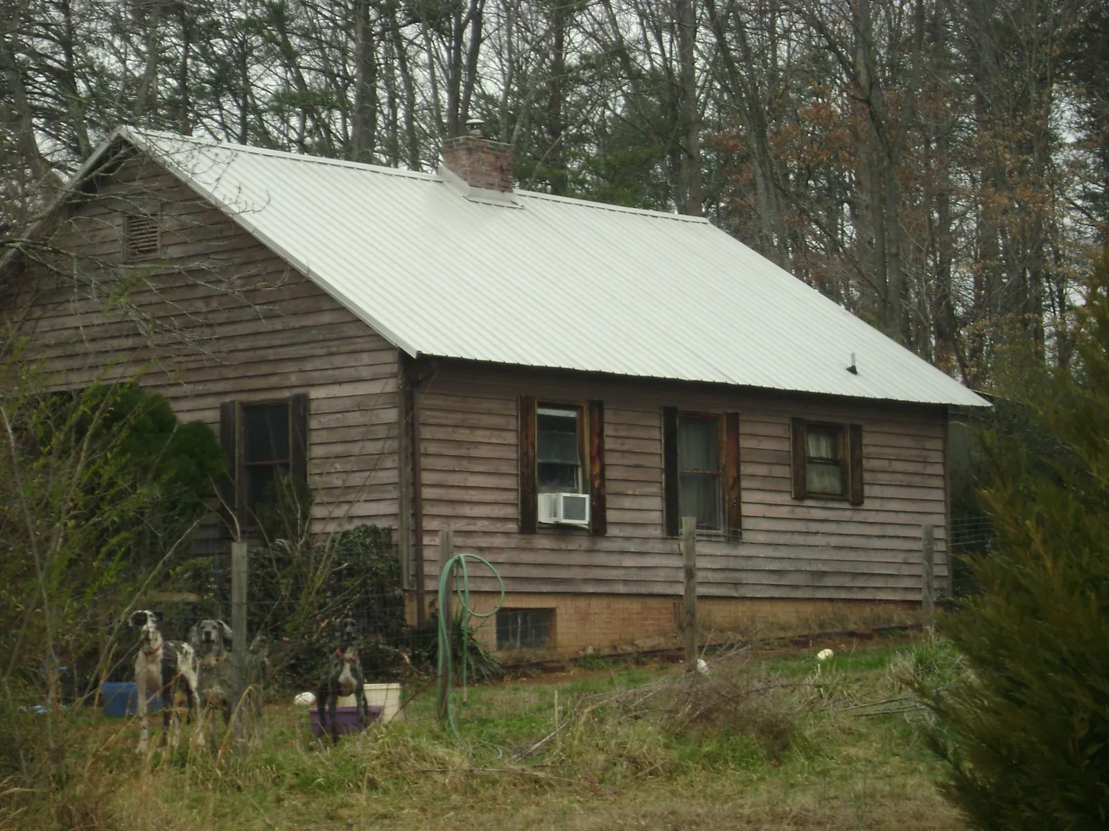 White metal roof on an old wood sided farmhouse, from a Metal Roof Installation job in Center City